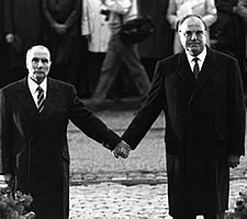 Helmut Kohl and François Mitterrand holding hands in the Douaumont cemetery, Verdun, in 1984.