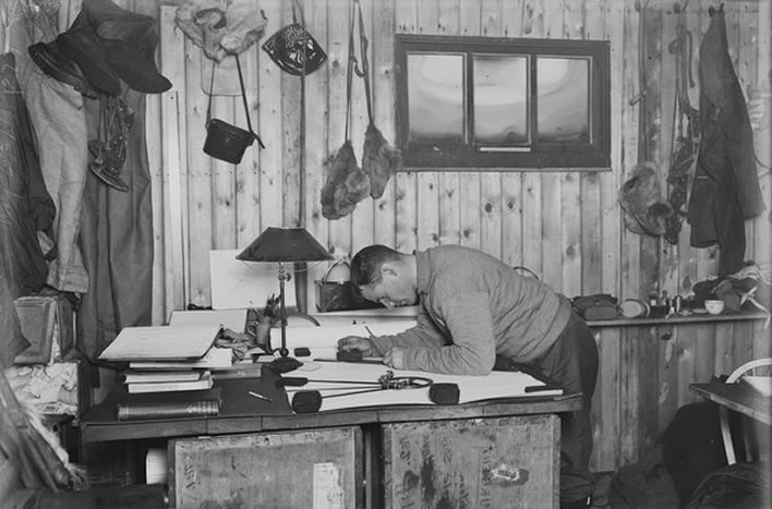 Terra Nova expedition: Teddy Evans working on a map in the hut at Cape Evans.
