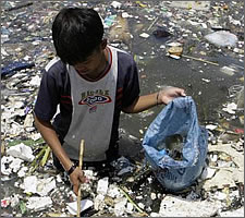 A boy collects plastic near a polluted coastline to sell in Manila, April 9, 2008. Image: Cheryl Ravelo / Reuters / PRI.