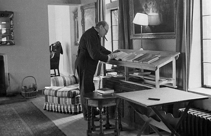 Churchill in his siren-suit at his standing-desk in his country home Chartwell in 1939.
